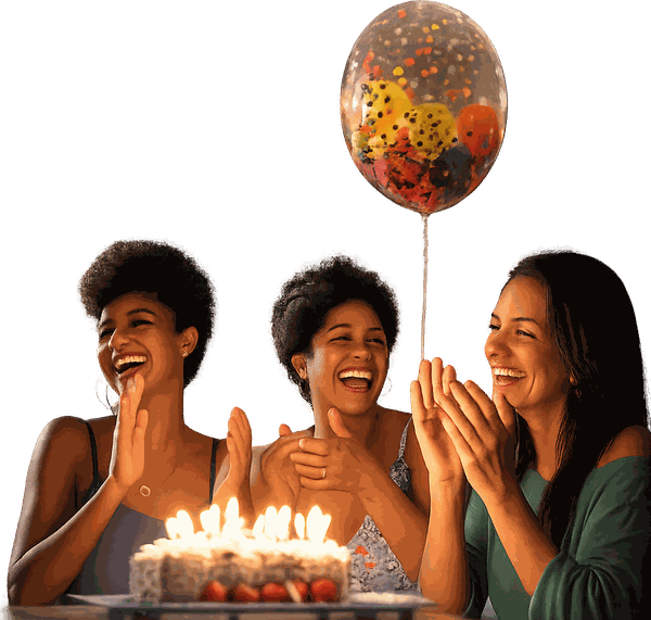 Three friends laughing together around a birthday cake with a balloon